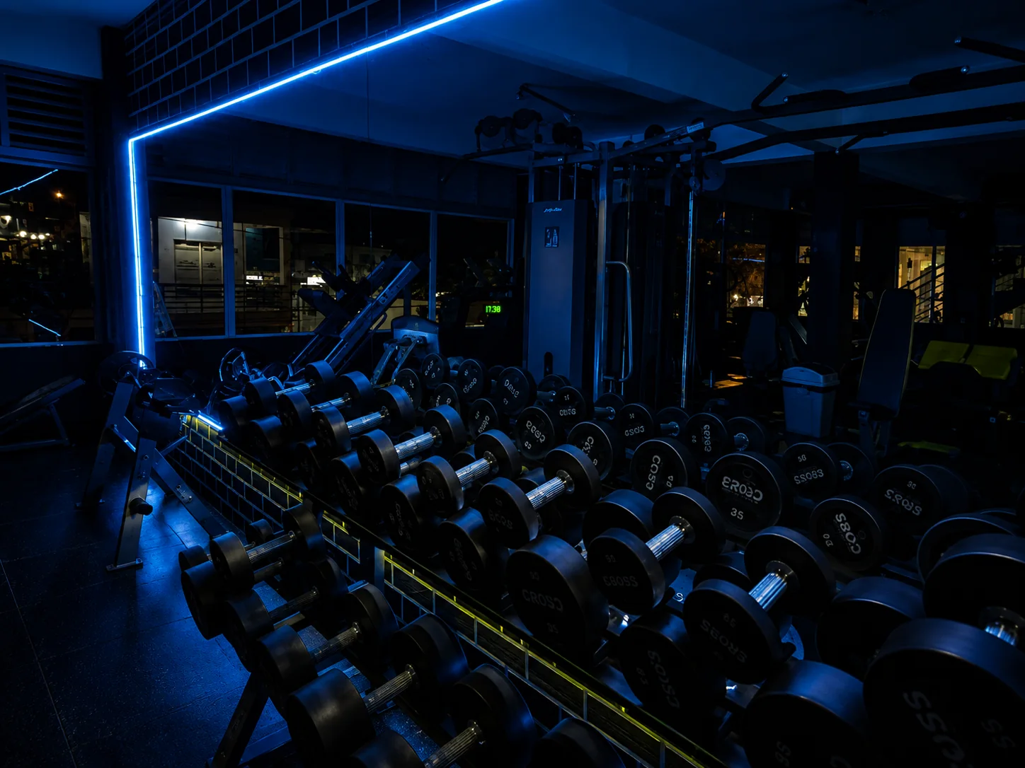 Área de mancuernas de Fitness Factory iluminada en azul